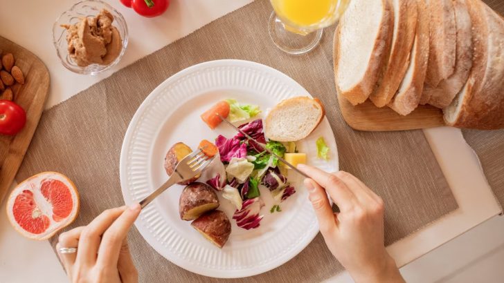 Top view of a nutritious breakfast setup with salad, bread, and fresh juice, perfect for a healthy start.